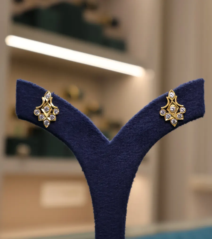Stone-set gold studs on a navy stand, on our Instagram